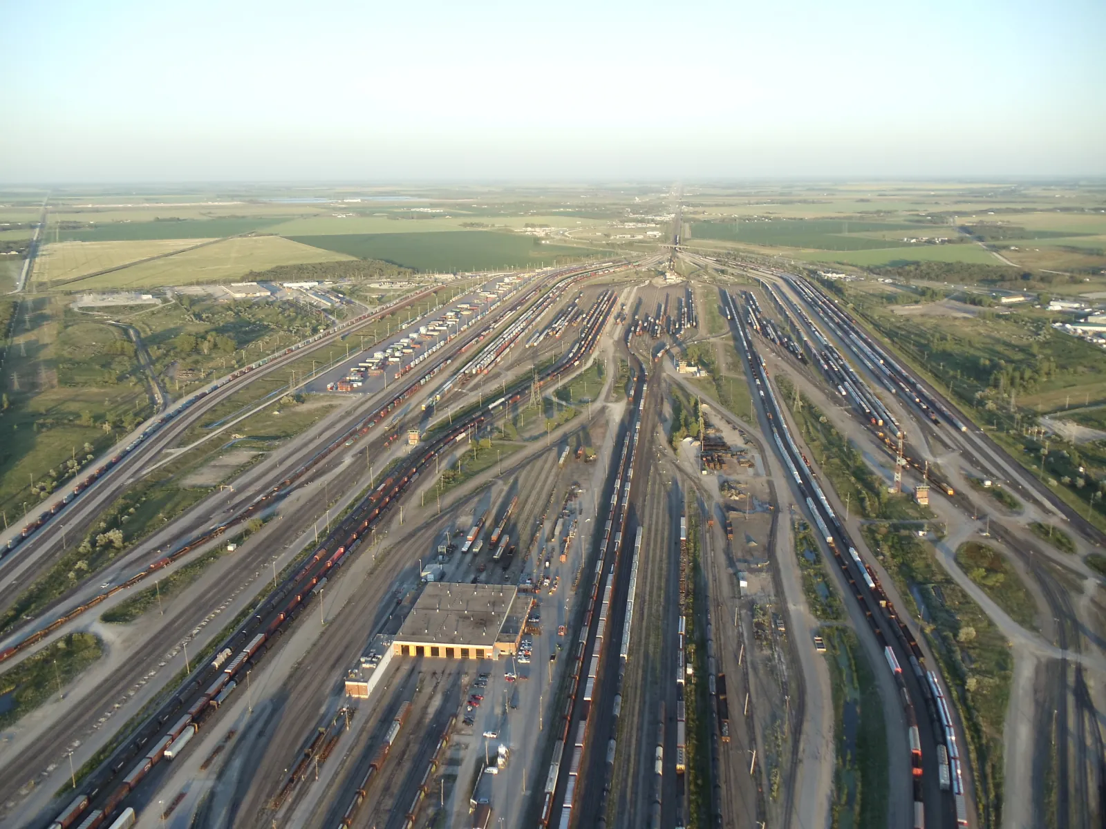 Aerial view of CN's Symington Yard rail classification yard in Winnipeg, Manitoba, with dozens of parallel tracks and freight cars fanning out across the Prairie
